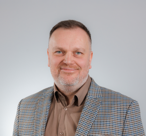 zdjęcie przedstawiające Mariusza Grinholca, w garniturze